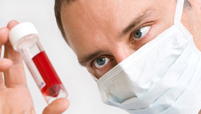 Close up of a male doctor looking at a blood sample