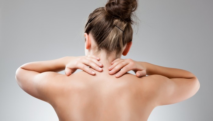 Woman massaging pain back isolated on white