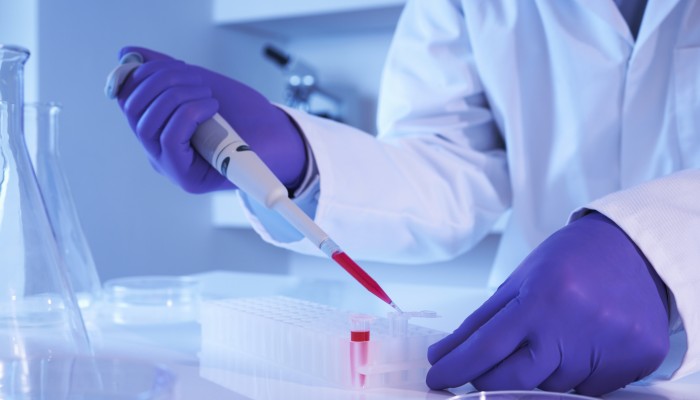 Scientist using pipette in laboratory