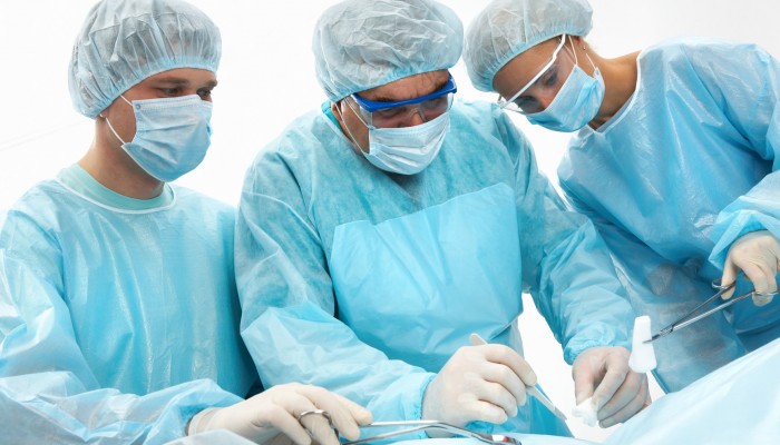 Three surgeons operating on a patient