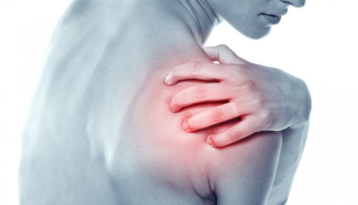 Acute pain in a shoulder at the young women. young girl keeps for a sick shoulder on a white background