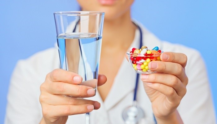 Pills, tablets and drugs heap in doctor hand, closeup view