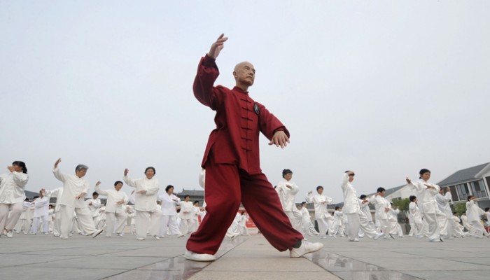 A man leads participants to perform Taiji, a traditional form of Chinese martial arts, in Liu'an, Anhui province July 13, 2008. Some residents from a local community attended the performance to celebrate the upcoming 2008 Beijing Olympic Games, China Daily reported. REUTERS/China Daily (CHINA). CHINA OUT. NO COMMERCIAL OR EDITORIAL SALES IN CHINA.