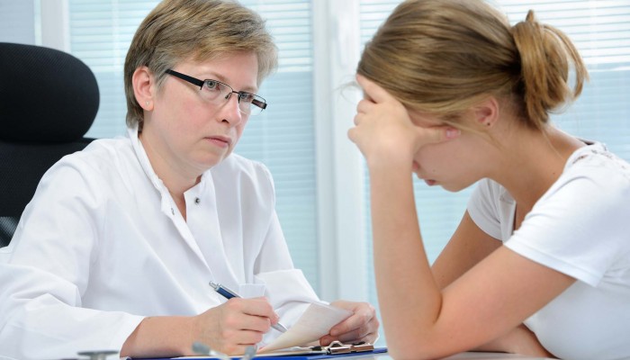 teenage girl suffering with depression in a conversation with a therapist